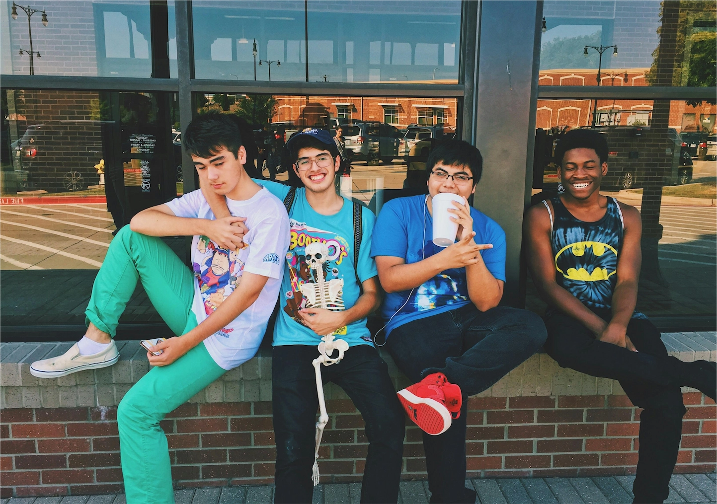 A group of four friends take a photo outside on campus