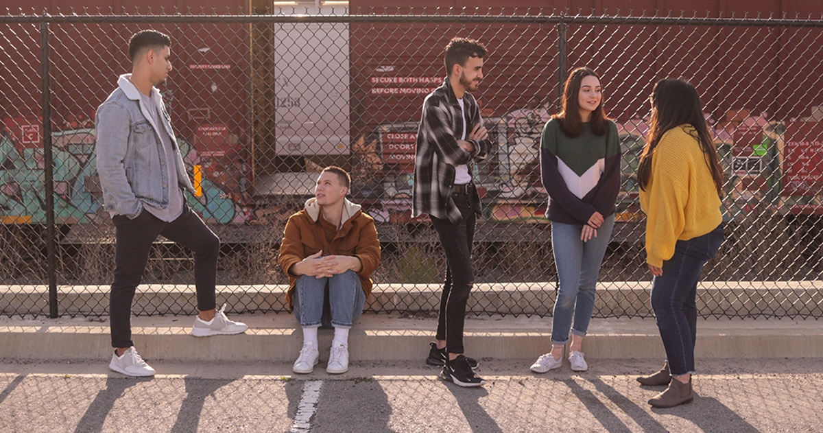 Group of young people talking outside on the street