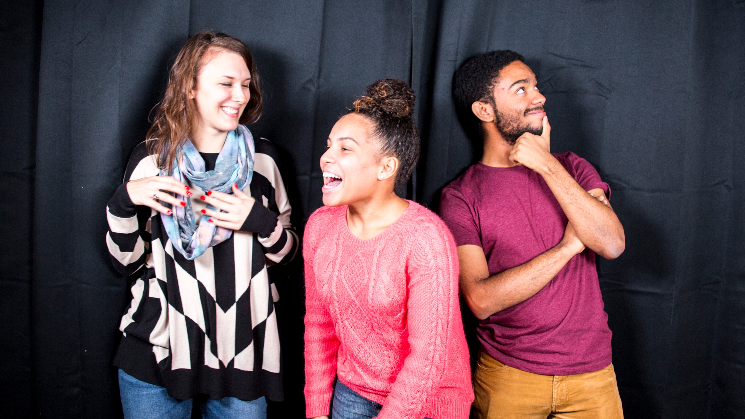 Three young people engaged in a humorous improv performance