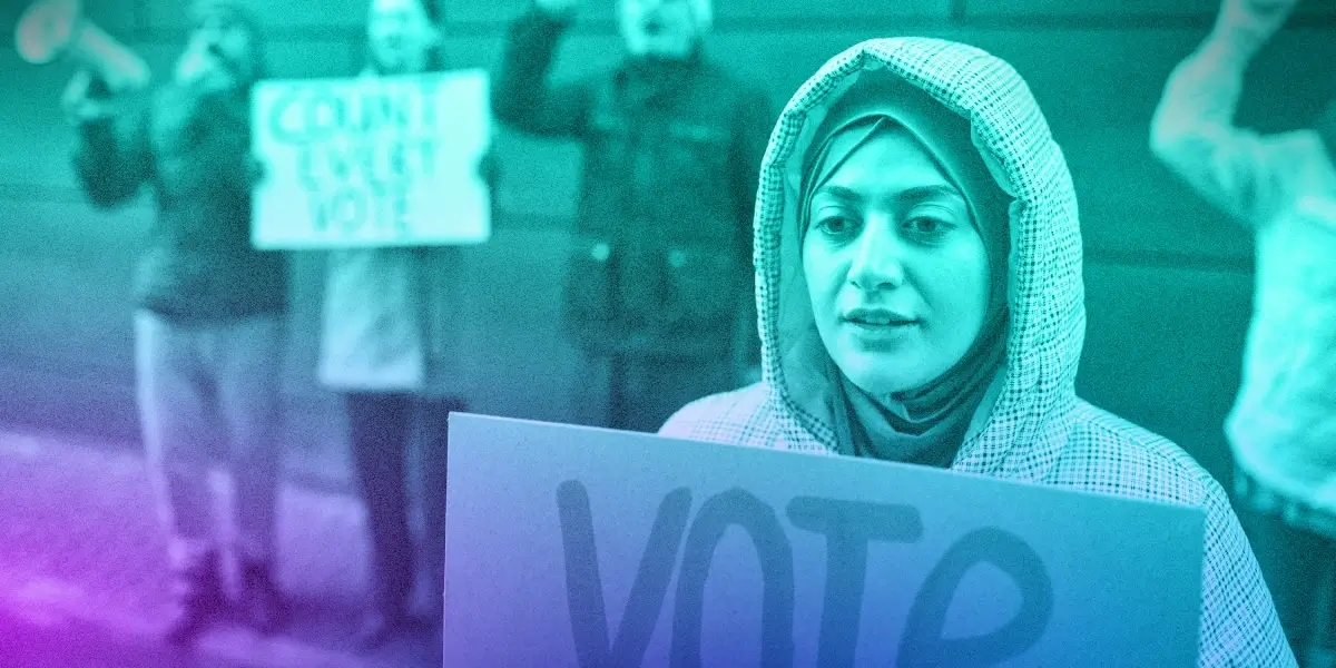 Young person holding a protest sign that says "VOTE"