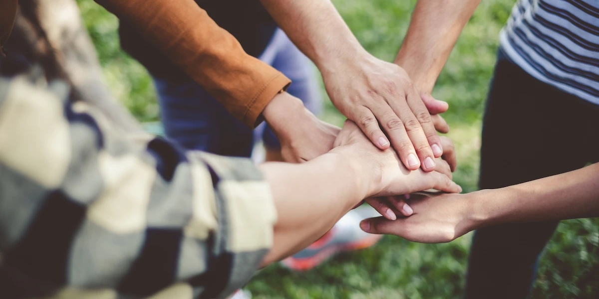 Young people put their hands on top of each other as a show of support