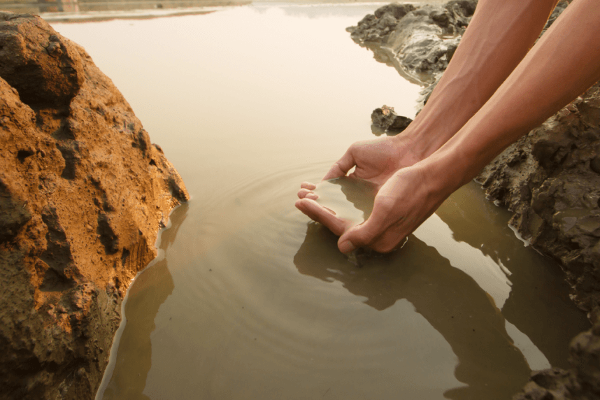 Hands holding muddy water