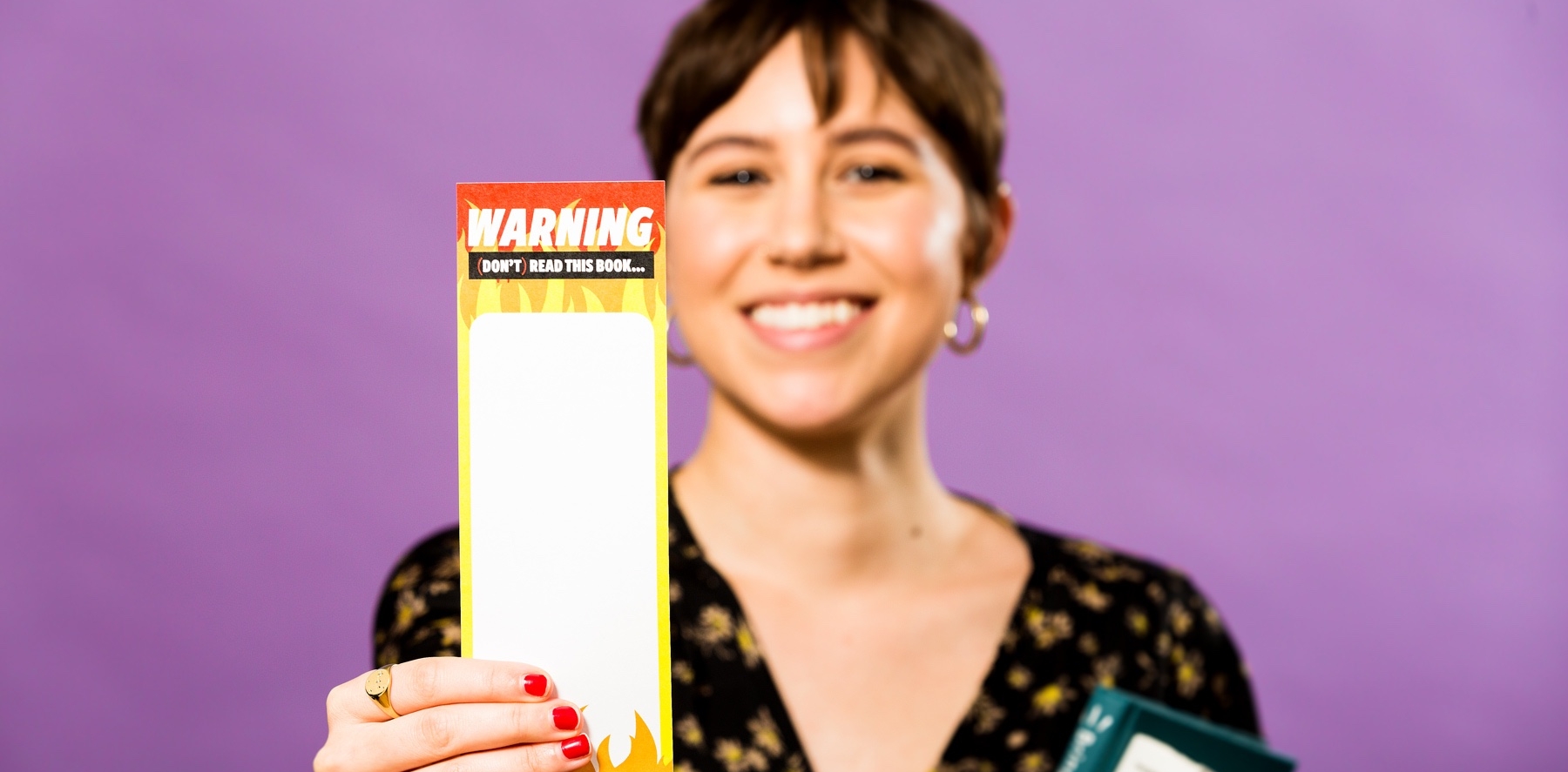 A DoSomething member holding up a bookmark to raise awareness about summertime skills loss