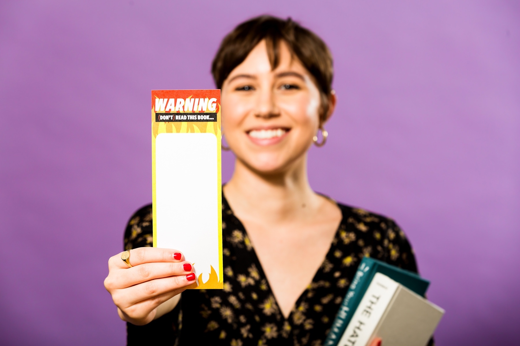 A DoSomething member holding up a bookmark to raise awareness about summertime skills loss