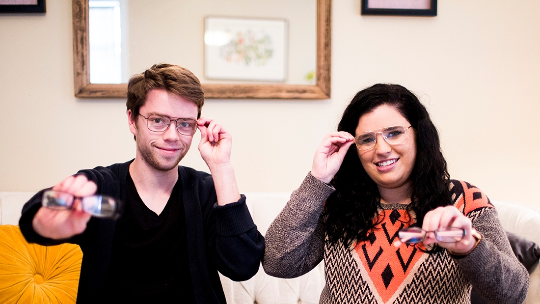 Two people holding up glasses they are about to donate