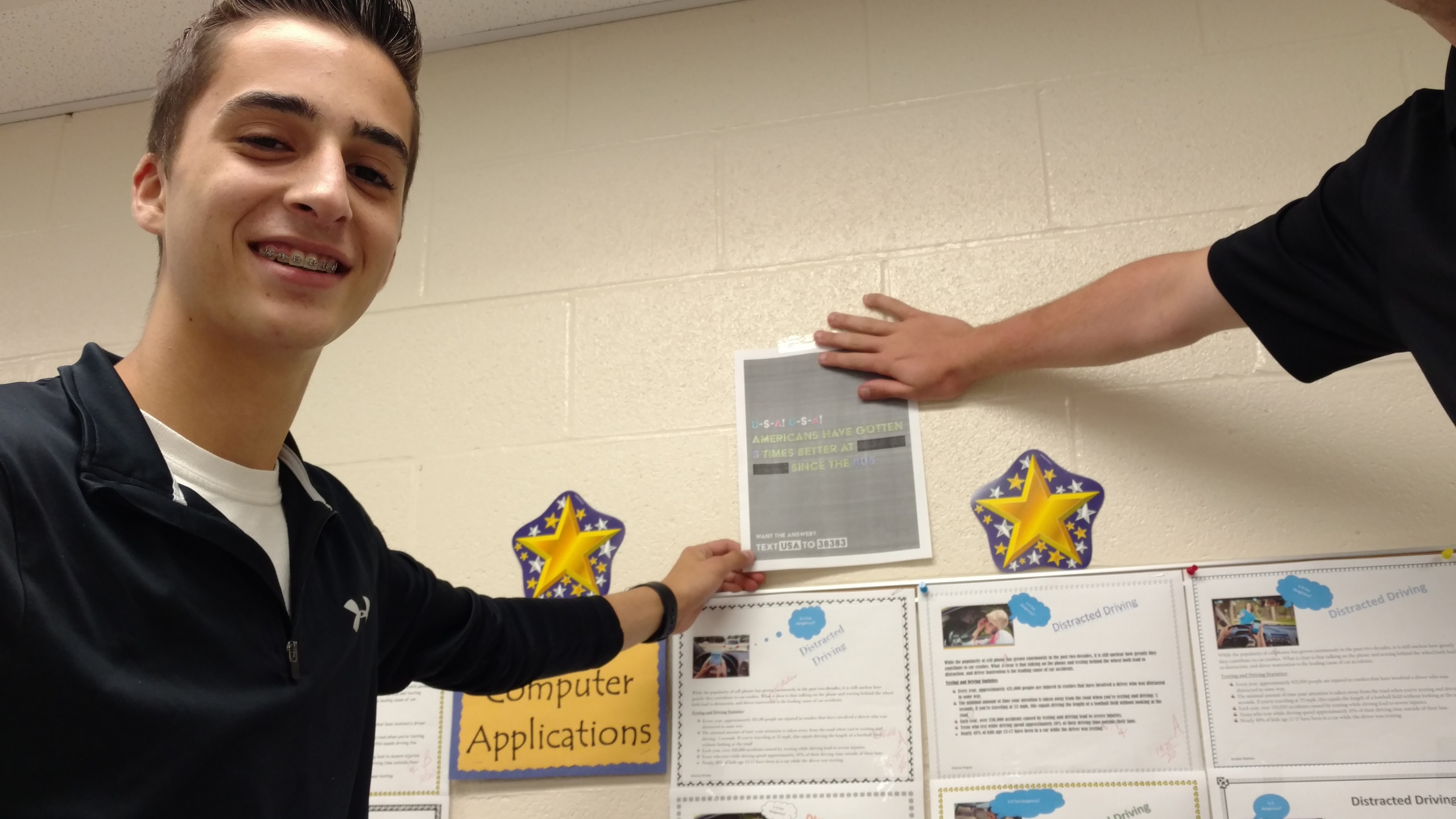 Two individuals are engaging with a poster on the wall that promotes civic engagement and awareness by highlighting improvements in safety. Brightly colored displays and educational content can be seen in the background, emphasizing community service and leadership opportunities.