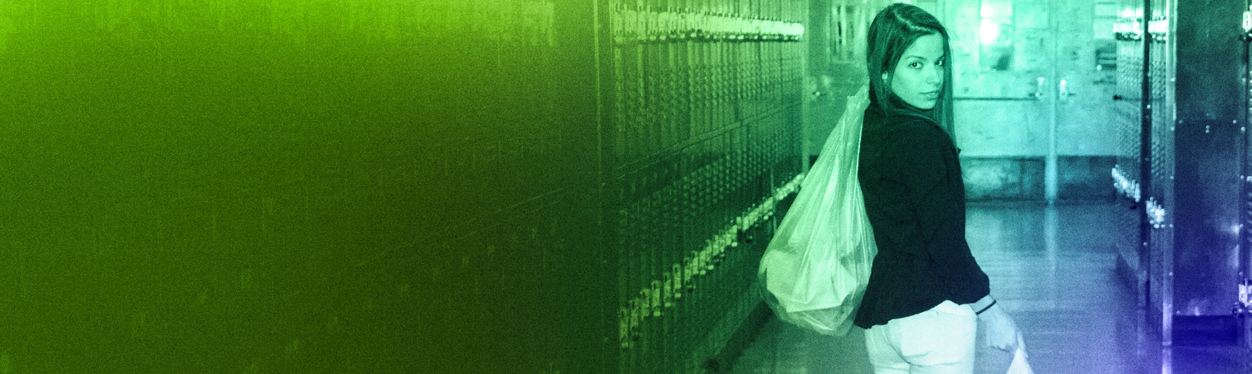 A DoSomething member carrying trash bags down a hallway of lockers