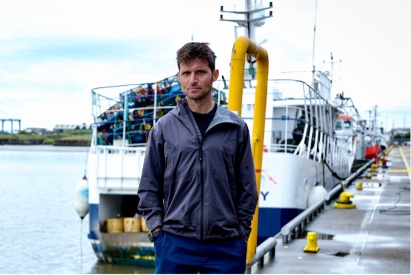 Guy Martin stood in front of a trawler