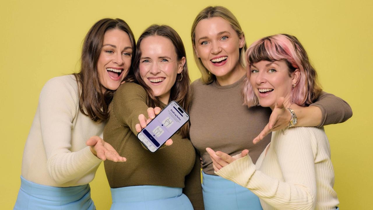 Four people laughing as one holds out a phone running the Fæbrik app