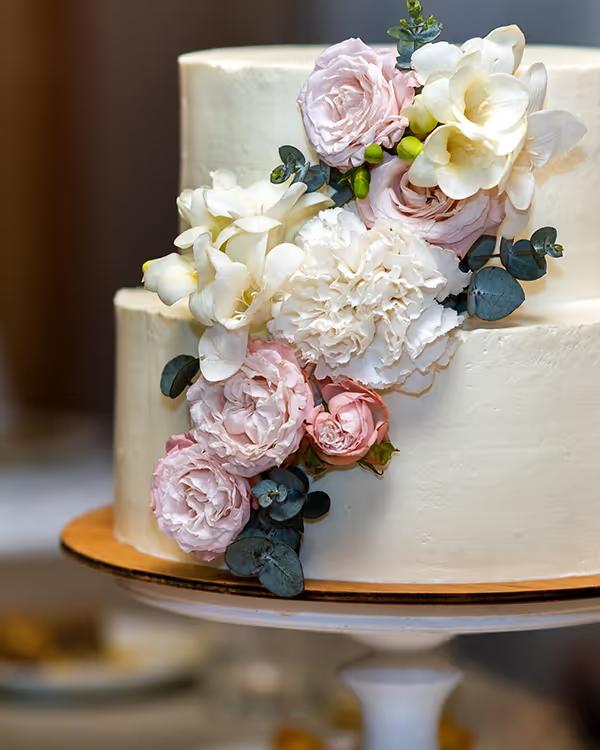 Two-tier wedding cake with pink and white flowers