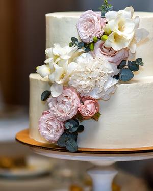 Two-tier wedding cake with pink and white flowers