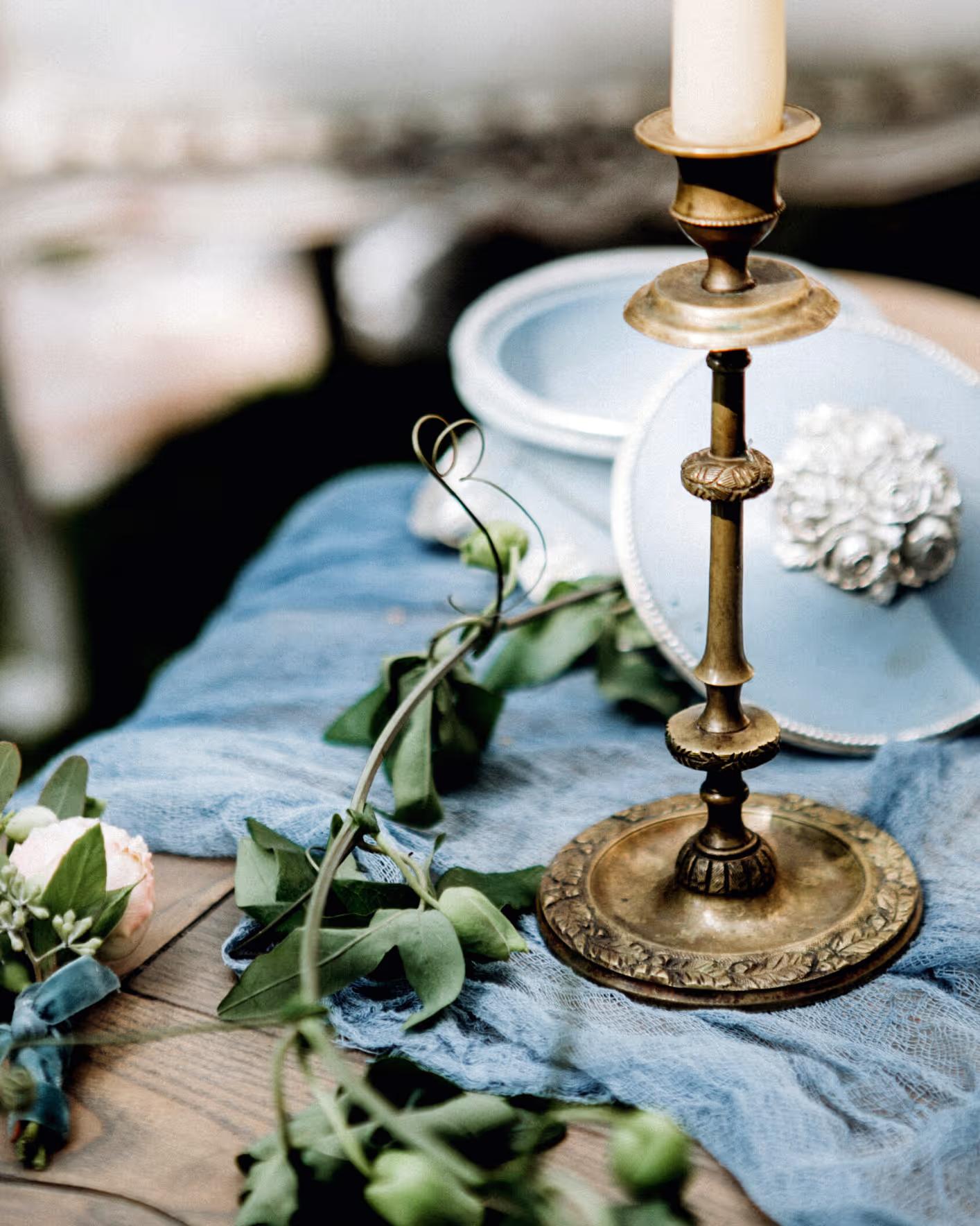 Brass candlestick and blue linen on a wedding table