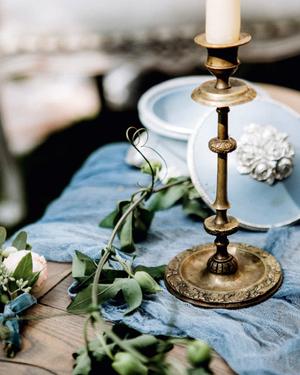 Brass candlestick and blue linen on a wedding table