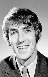 Black-and-white portrait of a smiling young man in a suit