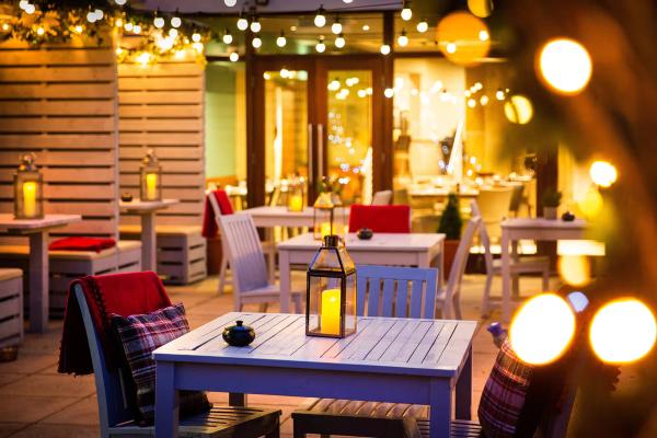 The garden in the evening, with fairy lights, lanterns and tartan cushions