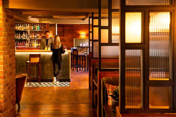 The Neighbourhood bar, seen past wooden booths with glass screens