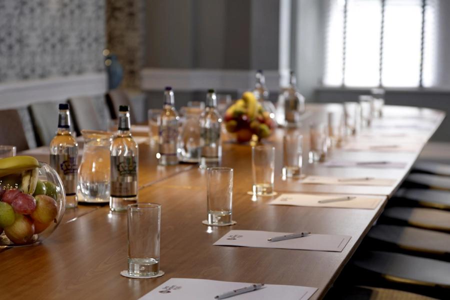 Boardroom table laid with water, glasses and notepads in the Cardoon Suite