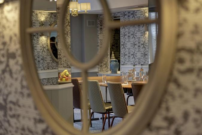Private dining room reflected in an ornate mirror