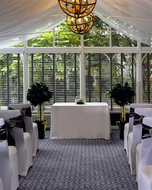 Conservatory ceremony room with white chairs either side of the aisle