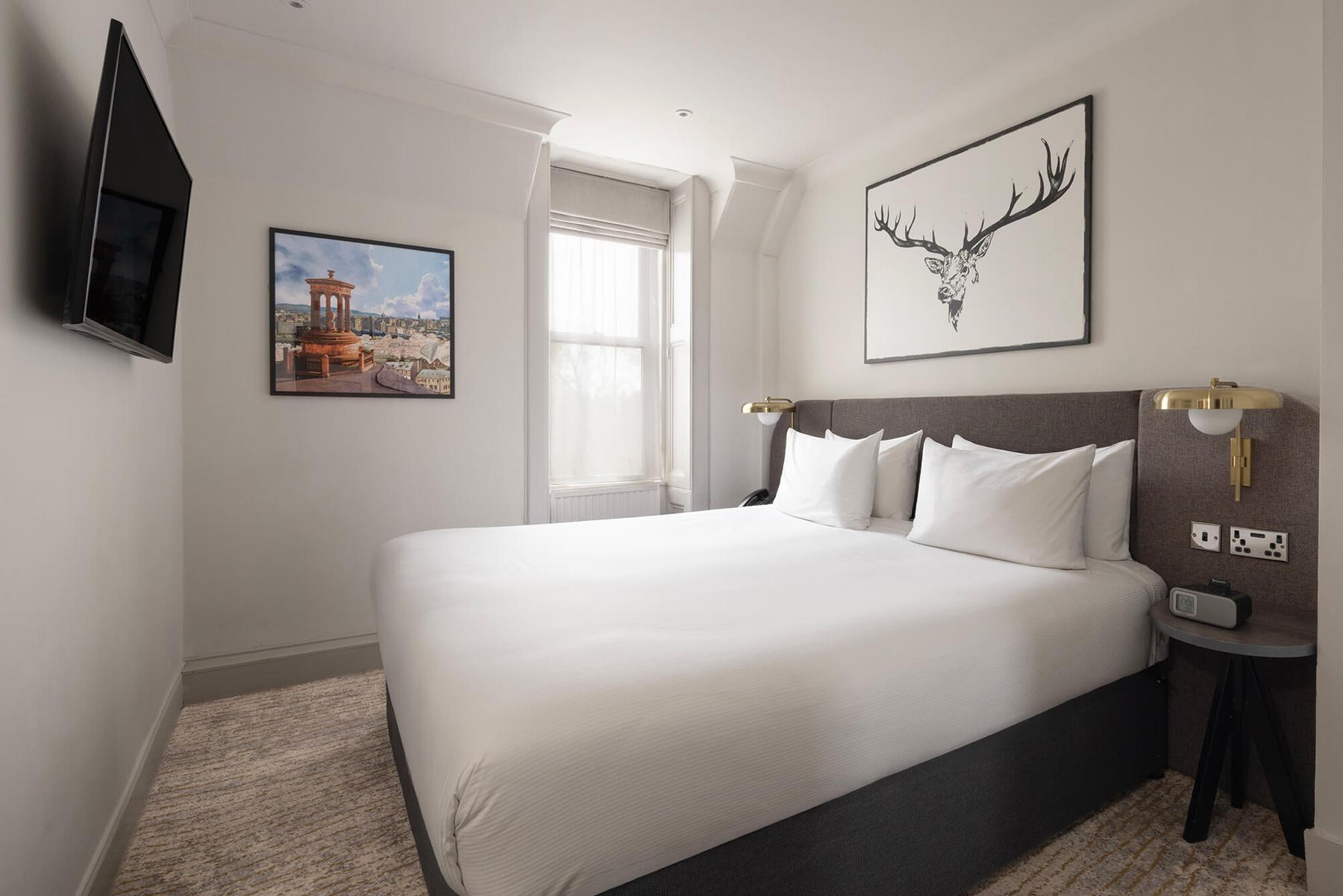 Superior bedroom with a large double bed and wall-mounted TV