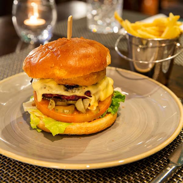 Cheeseburger with fries and a candle on the table