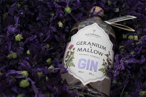 Bottle of Geranium and Mallow gin among purple flowers