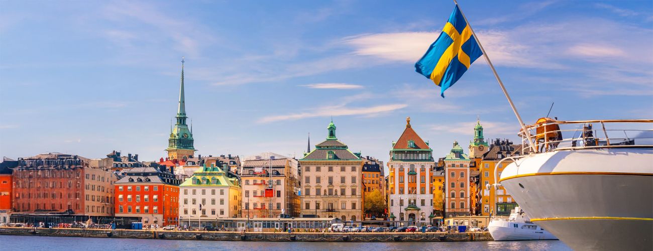 Stockholm waterfront beside a Swedish flag