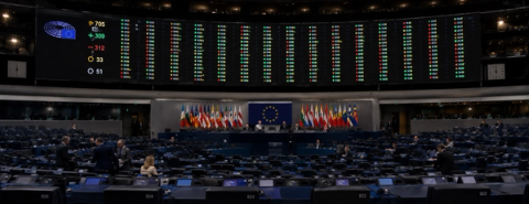 The European Parliament chamber beneath an electronic voting results board.