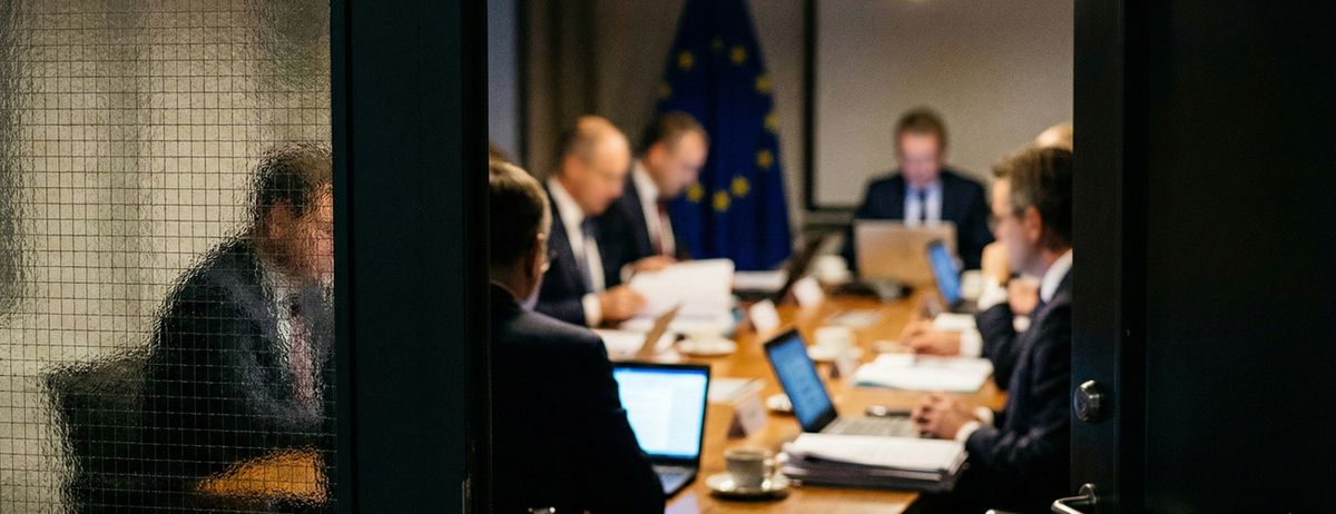 European Union officials meeting behind a glass wall