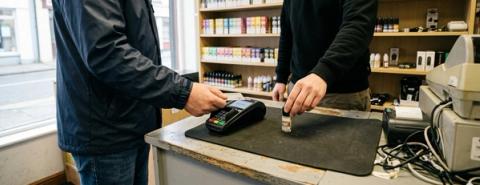 A customer pays for a bottle of e-liquid at the counter of an Irish vape shop.