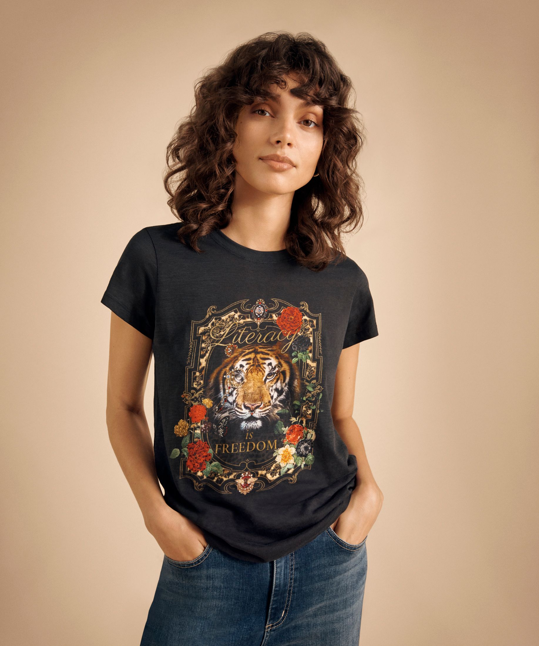 DJ x ALNF shirt being worn by a model on a photo backdrop