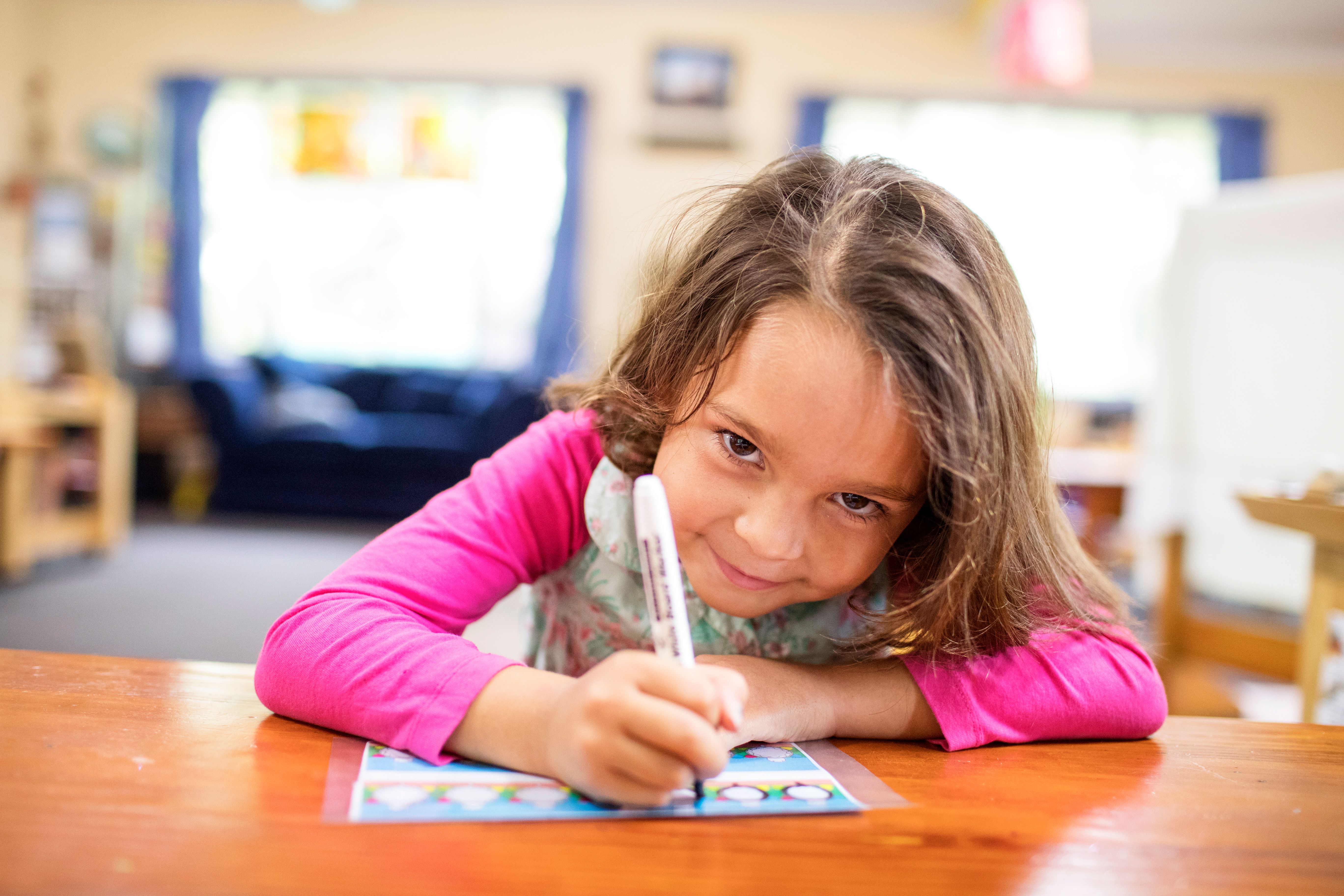 A child working on a workbook in a classroom