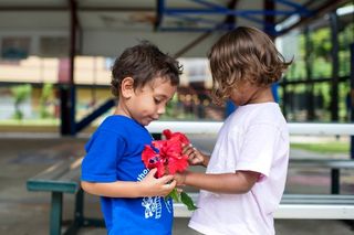 Two children holding a flower