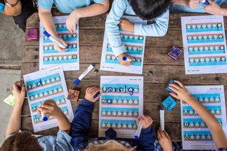 Top down photo of children working on spelling workbooks