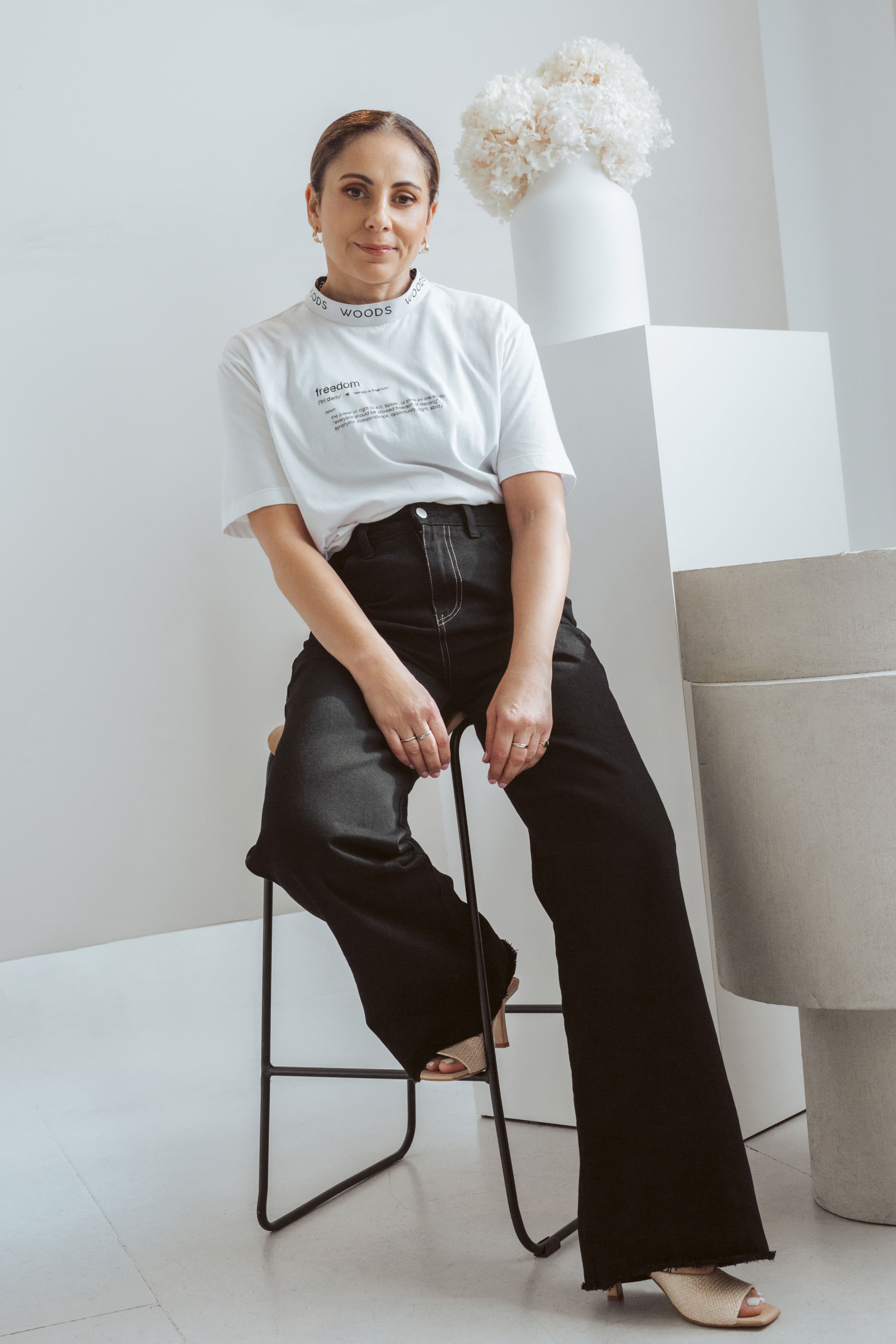 DJ x ALNF shirt being worn by a model on a photo backdrop