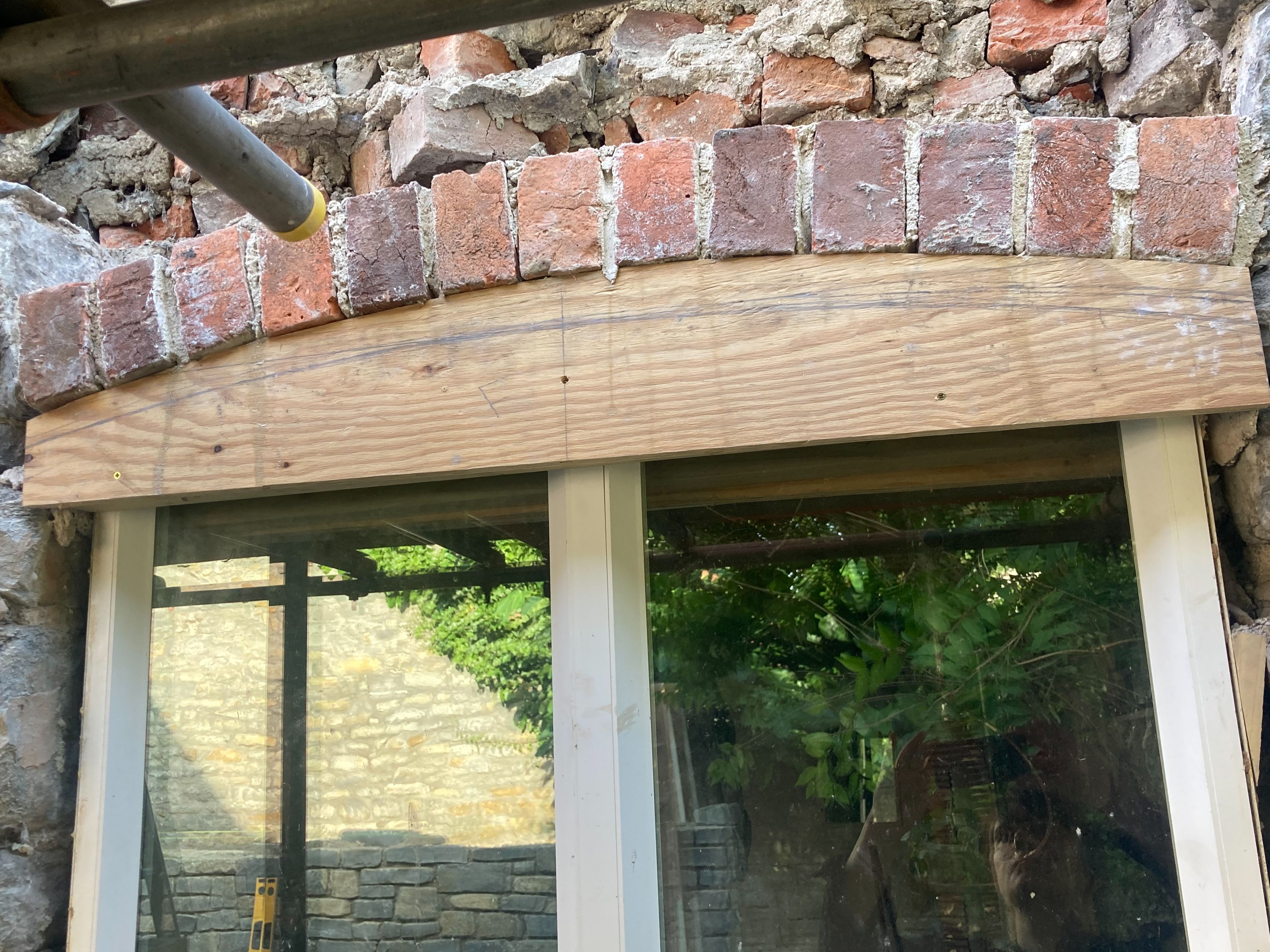 brick arch being installed over a wooden form with scaffolding