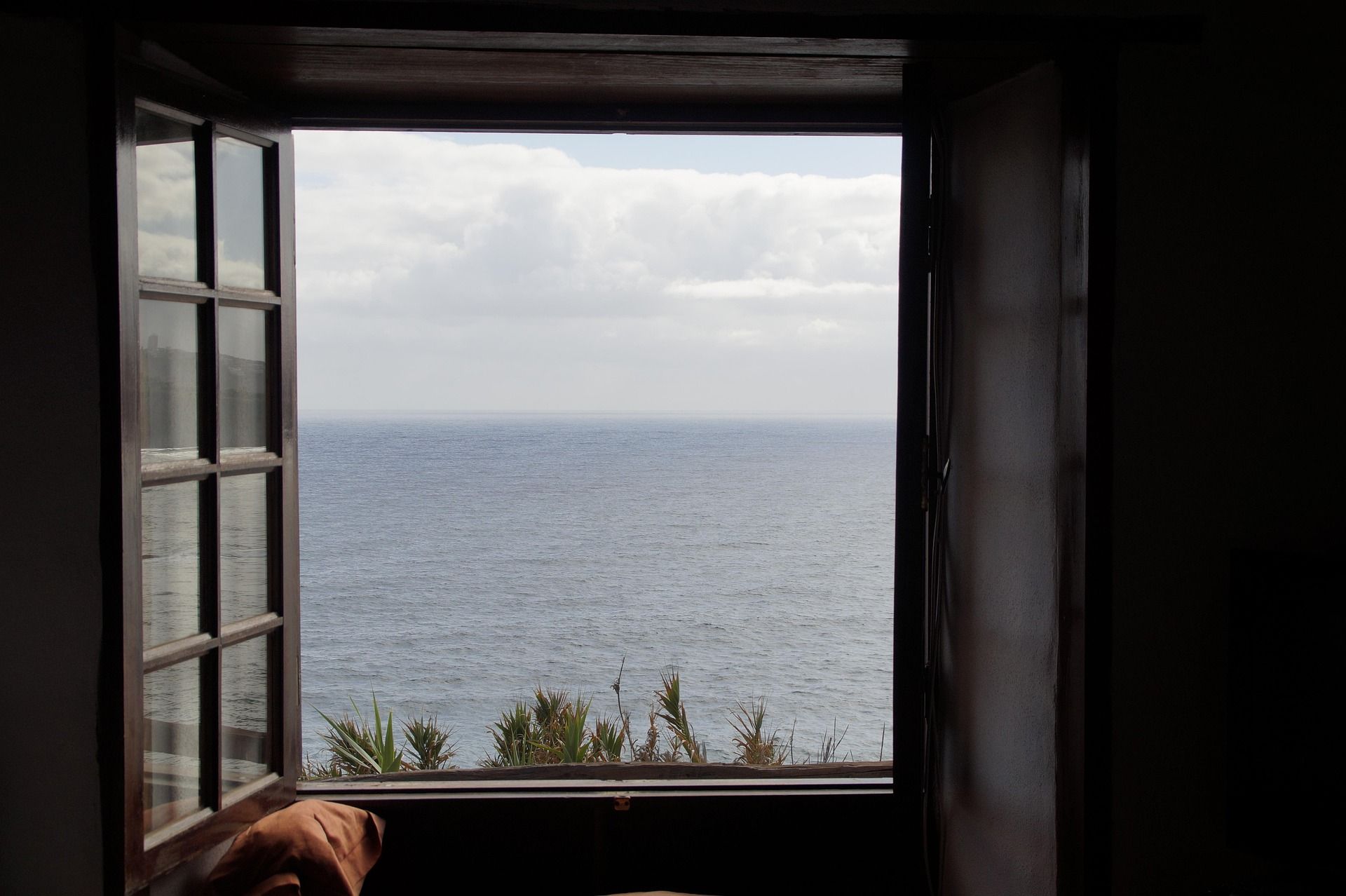 photo of a window with a sea view through it