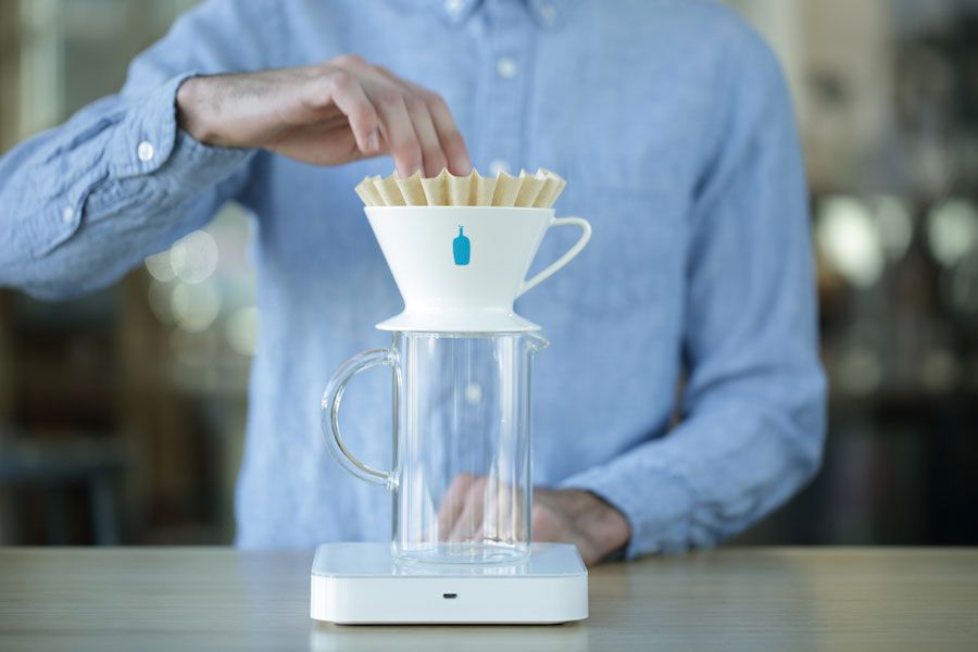 putting a blue bottle coffee filter into a blue bottle coffee dripper