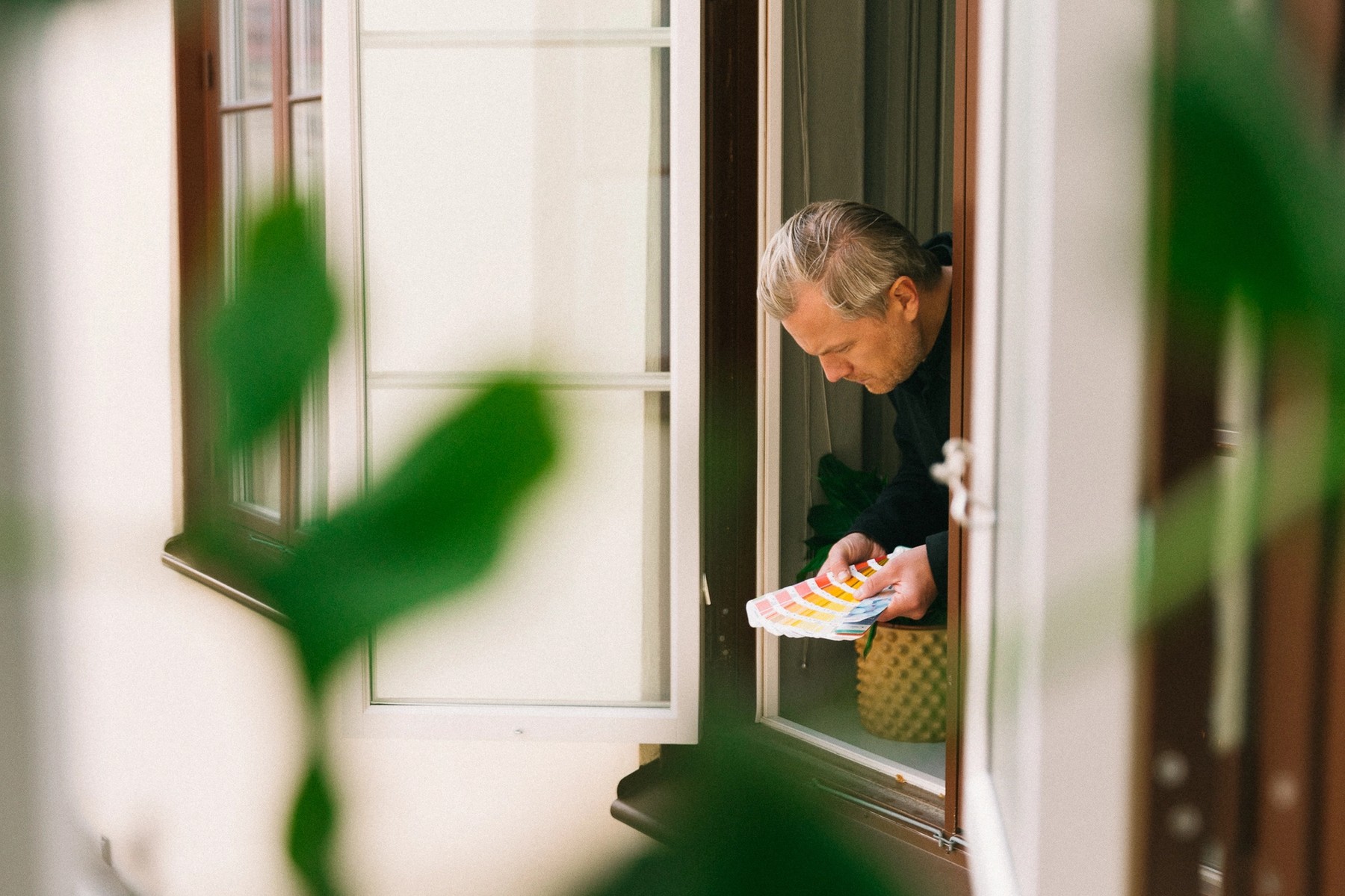 Man in window looking at colour samples