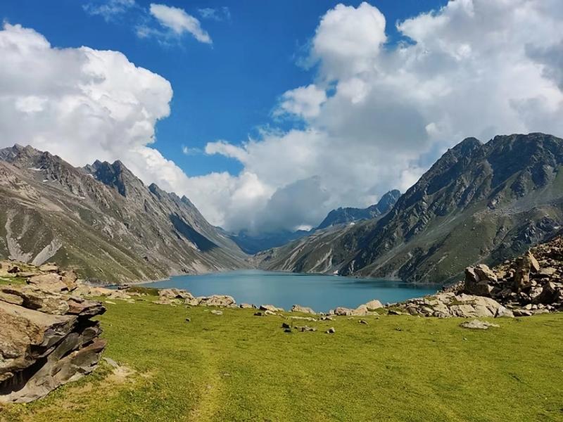 Trekker walking through lush meadows on Kashmir Great Lakes Trek route
