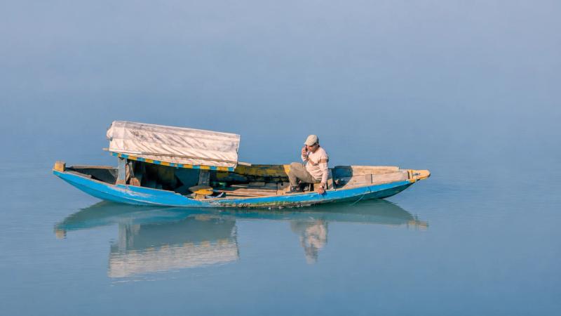 Kashmir SIM card for tourists enjoying a peaceful shikara ride on a Kashmiri lake.
