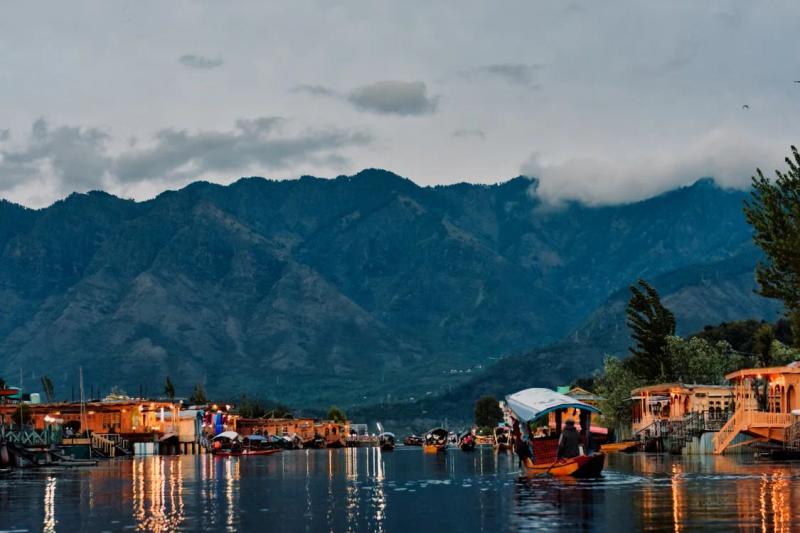 Shikaras and lit houseboats on Dal Lake at dusk, a peaceful stop on a Kashmir Tour for Senior Citizens