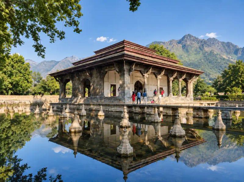 Nishat Bagh Srinagar pavilion reflected in a still water tank with mountains in the background