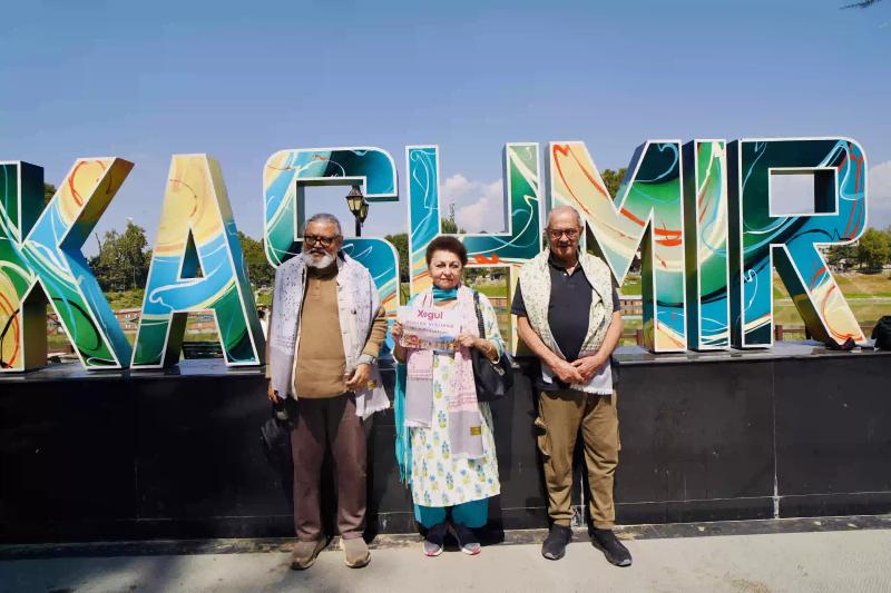 Kashmir by Train experience with travelers posing at a colorful Kashmir landmark during their scenic journey.