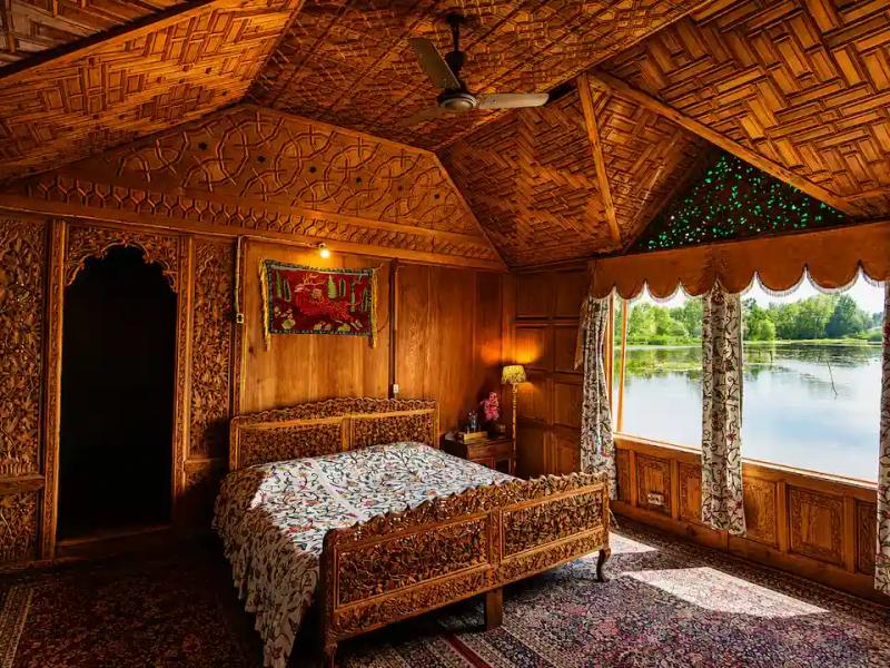 Intricately carved cedar wood interior of a luxury Dal Lake houseboat, curated and vetted by the best local tour operator in Kashmir.