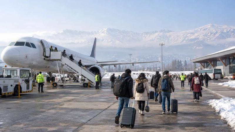 Travelers arriving at Srinagar Airport with snow-covered mountains during Kashmir in January