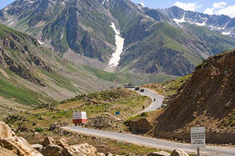 How to Reach Gurez Valley via a scenic mountain road with snow-covered peaks and winding alpine terrain.
