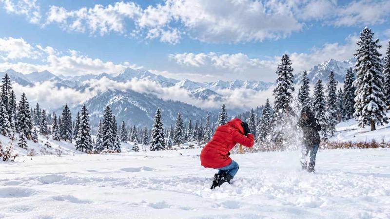 Travelers enjoying a snowball fight in the snow-covered meadows of Gulmarg