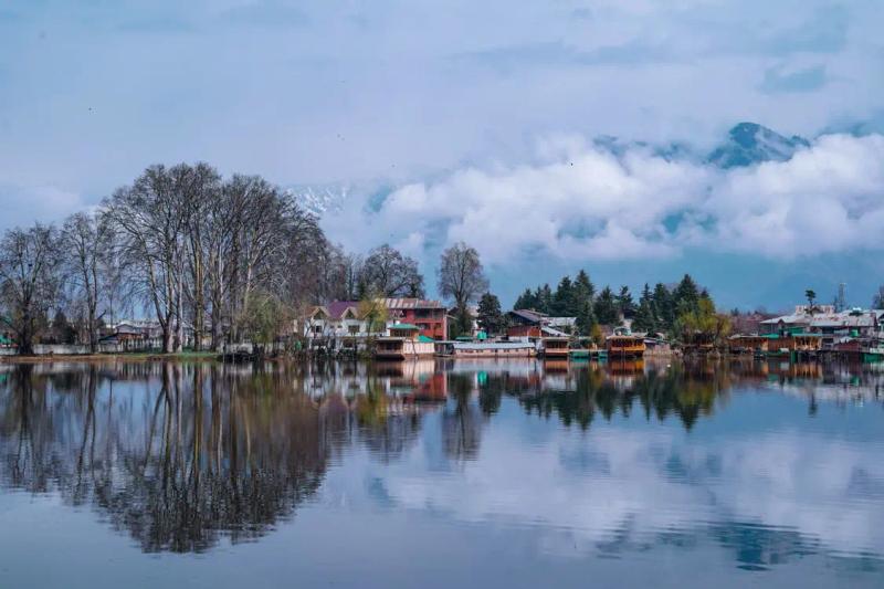 Shikara on misty lake seen through a wooden frame, Dal Lake vs Nigeen Lake houseboat stay