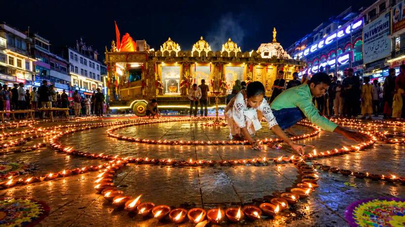Family lighting diyas and candles at an evening prayer spot, Diwali in Kashmir